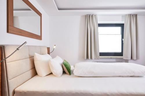 a bedroom with a bed and a window at Hotel Rosenstock - Erwachsenenhotel - Adults only 15 plus in Fischen