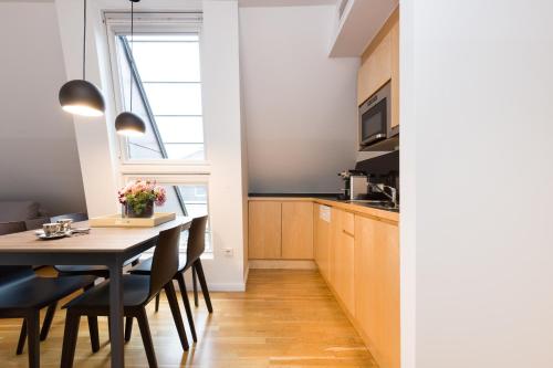 a kitchen and dining room with a table and chairs at RAFAEL KAISER - Premium Apartments City Centre - Contactless Check-In in Vienna