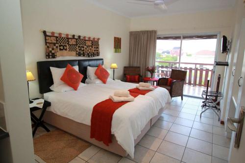 a bedroom with a large bed and a balcony at Haus Giotto in Gansbaai