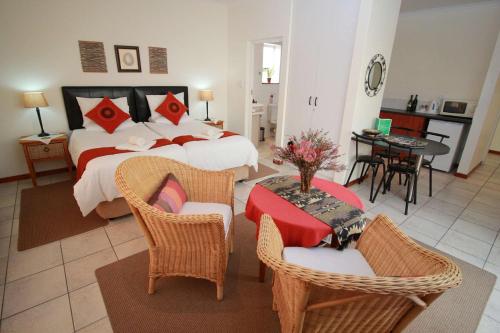 a bedroom with a bed and a table and chairs at Haus Giotto in Gansbaai