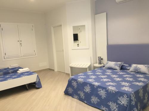 Schlafzimmer mit einem blauen und weißen Bett und einem Tisch in der Unterkunft Villa Belvedere Salento in Porto Cesareo