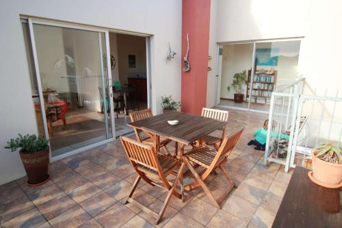 a dining room with a wooden table and chairs at Haus Giotto in Gansbaai