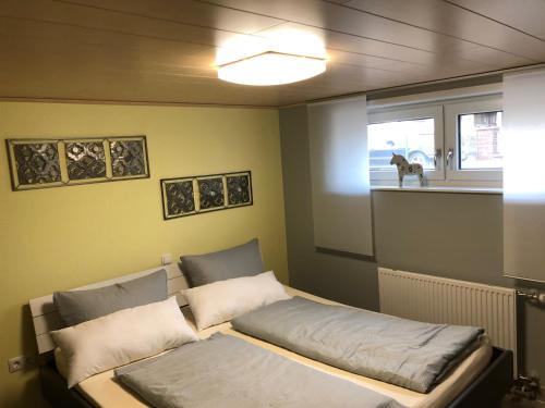 a bed in a room with a dog in a window at Gästehaus Alwin Diebold - 5 Gehminuten zum Europapark in Rust