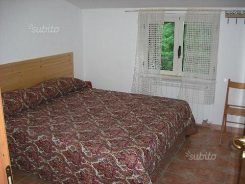 カミリアテッロ・シラーノにあるVilletta lo Scoiattoloのベッドルーム1室(ベッド1台、椅子、窓付)