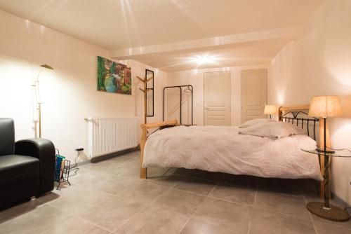 Un dormitorio con una cama y una lámpara. en Maison d'hôtes Aux Deux Cigognes, en Gries