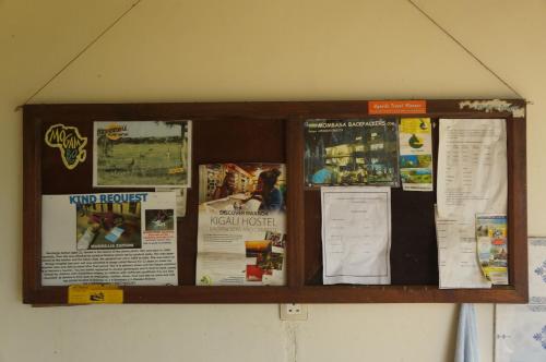 a bulletin board with posters and papers on a wall at Masaka Backpackers, Tourists Cottage & Campsite in Masaka