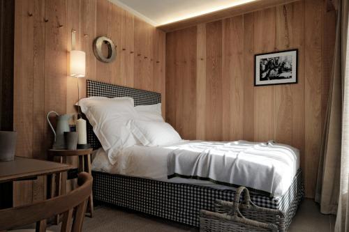a bedroom with a bed with white sheets and pillows at Eden Hotel in Bormio