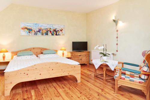 a bedroom with a wooden bed and a tv at Hotel Garni Schöne Aussichten in Klöch