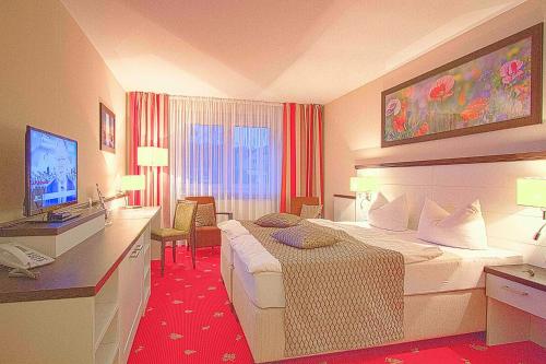 a hotel room with two beds and a television at Falk Seehotel Plau am See in Plau am See
