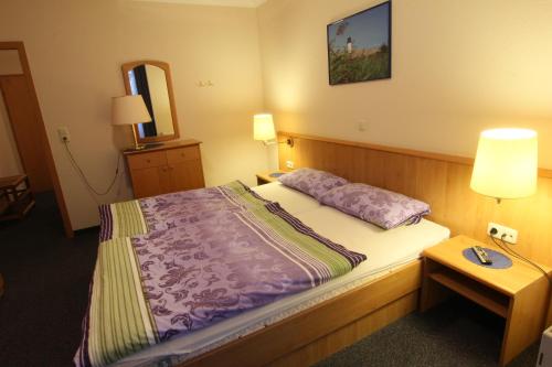 a hotel room with a bed and a mirror at Residenz Albatros in Cuxhaven