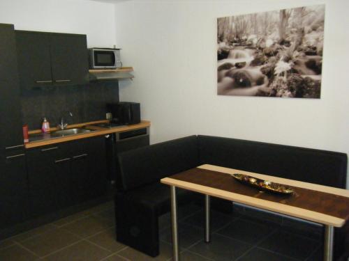 a small kitchen with a table and a sink at Wietheger´s Ferienwohnungen Gästehaus Strycktal II in Willingen