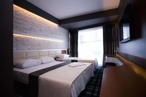 ein Hotelzimmer mit zwei Betten und einem Fenster in der Unterkunft Aripsas Hotel in Giresun