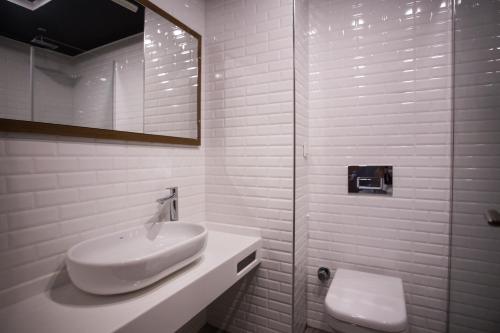 ein weißes Badezimmer mit Waschbecken und Dusche in der Unterkunft Aripsas Hotel in Giresun