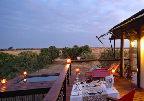 a wooden deck with a table and chairs on a balcony at Olare Mara Kempinski in Talek