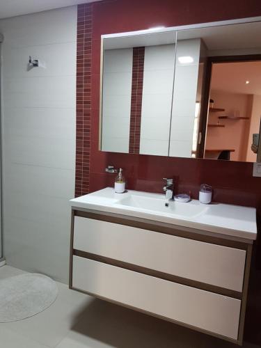 ein Badezimmer mit einem weißen Waschbecken und einem Spiegel in der Unterkunft HB-3600 in La Paz
