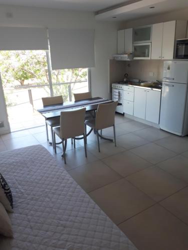 a kitchen with a table and chairs and a kitchen with white cabinets at Frente al Río in Paraná