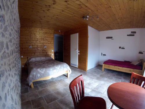 a bedroom with a bed and a table and chairs at Hotel restaurant Le Chamois in Ancelle