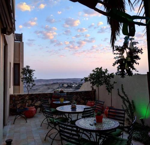 a patio with tables and chairs and a view of the desert at Yehelim Boutique Hotel in Arad