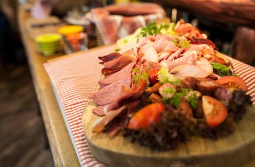 a cutting board with meat and vegetables on a table at Hotel Am Markt in Munich