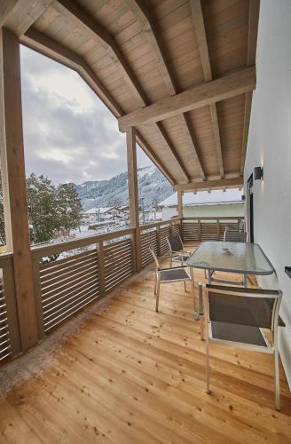 a room with a table and chairs on a balcony at Holiday Penthouse Moosweg in Maishofen