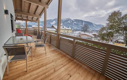 a balcony with a table and chairs and mountains at Holiday Penthouse Moosweg in Maishofen