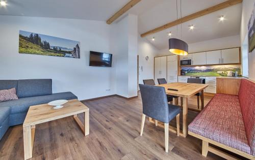 een woonkamer met een bank en een tafel bij Holiday Penthouse Moosweg in Maishofen