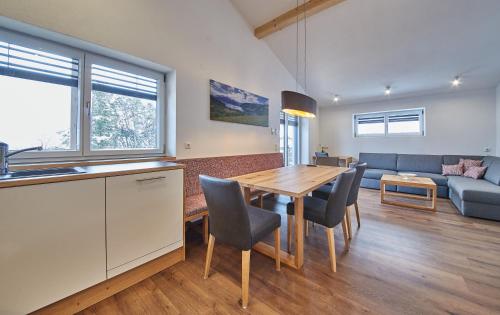 a kitchen and living room with a wooden table and chairs at Holiday Penthouse Moosweg in Maishofen