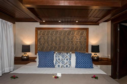 a bedroom with a large bed with blue and white pillows at Hotel Sombra e Água Fresca in Pipa
