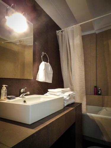 a bathroom with a sink and a mirror and a tub at Villa Nafplio in Nafplio