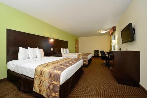 a hotel room with two beds and a desk at Americas Best Value Inn Lake Charles Interstate 210 in Lake Charles