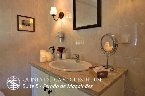 a bathroom with a sink and a mirror and candles at Quinta do Cabo Guesthouse in Sintra