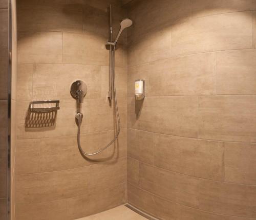 a shower with a shower head in a bathroom at Gasthof Ellmauer Hof in Ellmau