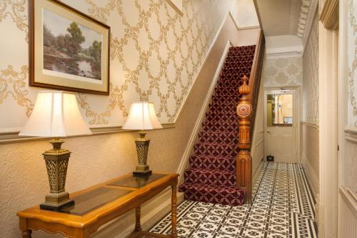 a living room with a staircase leading to a dining room at Lincoln House Private Hotel in Cardiff
