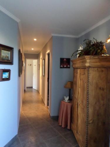 a hallway with a large wooden cabinet and a table at Les Broussous in Sauve