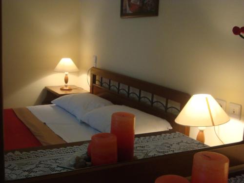 a bedroom with a bed with two lamps and a mirror at Stalaktites in Ioannina