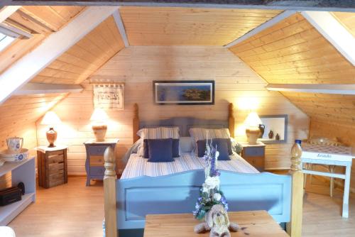 a bedroom with a bed in a room with wooden walls at Les Bruyères du Mont in Céaux