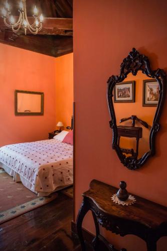 a bedroom with a bed and a mirror on the wall at Hotel Rural Orotava in La Orotava