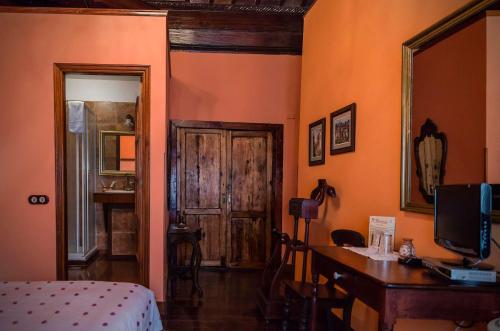 
a room with a bed, a table and a mirror at Hotel Rural Orotava in La Orotava
