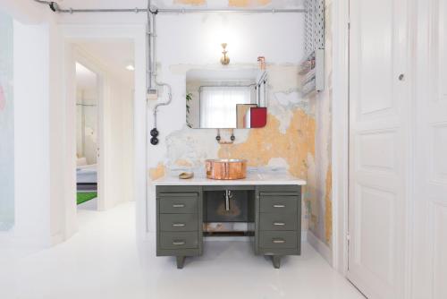 a bathroom with a sink and a pot on a counter at Trilogy Experimental in Thessaloniki