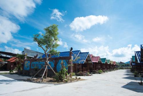 a row of houses with colorful roofs on a street at Talad Nam Klong Hae Resort in Hat Yai