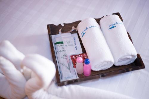 a hand reaches for a group of toilet paper and toothbrushes at Talad Nam Klong Hae Resort in Hat Yai