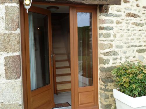 a wooden front door of a stone house at Les Bruyères du Mont in Céaux