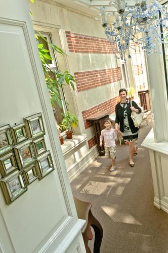 a woman and a child walking down a hallway at Hôtel L'Yeuse - Teritoria in Châteaubernard