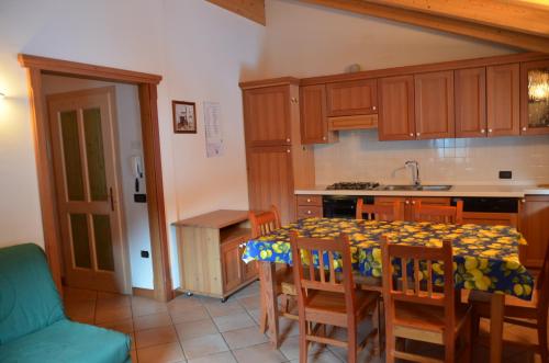 a kitchen with a table and chairs and a kitchen with a sink at Casa Tomaselli in Pellizzano
