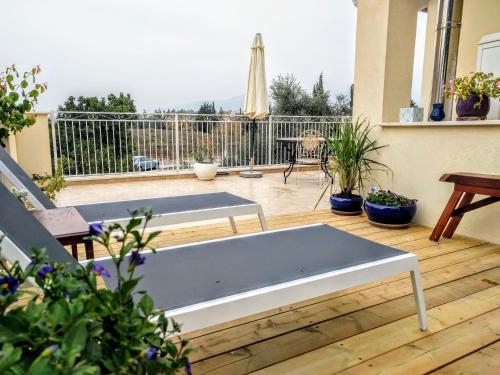 a white bench sitting on a wooden deck with plants at על שפת הבניאס in Sede Neẖemya