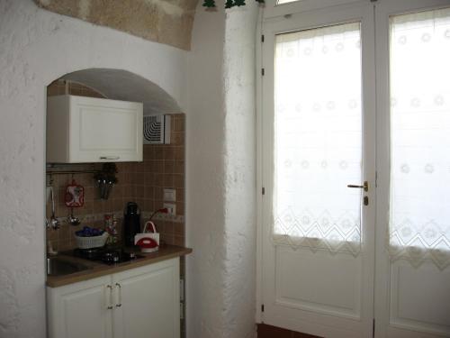 una cucina con armadietti bianchi e una porta bianca di La Seta Nei Sassi a Matera