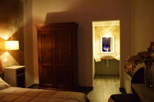 a bedroom with a bed and a cabinet and a mirror at Le Checche in Pienza