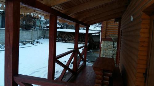a view from the porch of a cabin with snow at Karpatska Mria in Yaremche