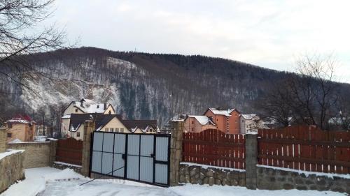 a fence in front of a village in the snow at Karpatska Mria in Yaremche