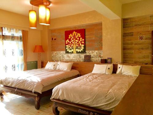 a bedroom with two beds in a room at Home & Teak Homestay in Jinning